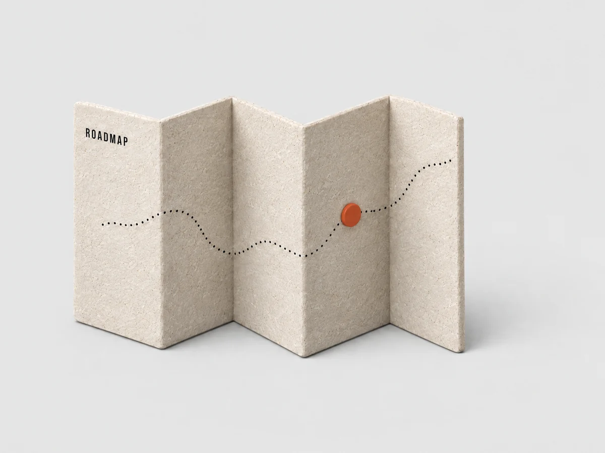 Un mapa de piedra plegado con un marcador naranja, con la etiqueta Roadmap